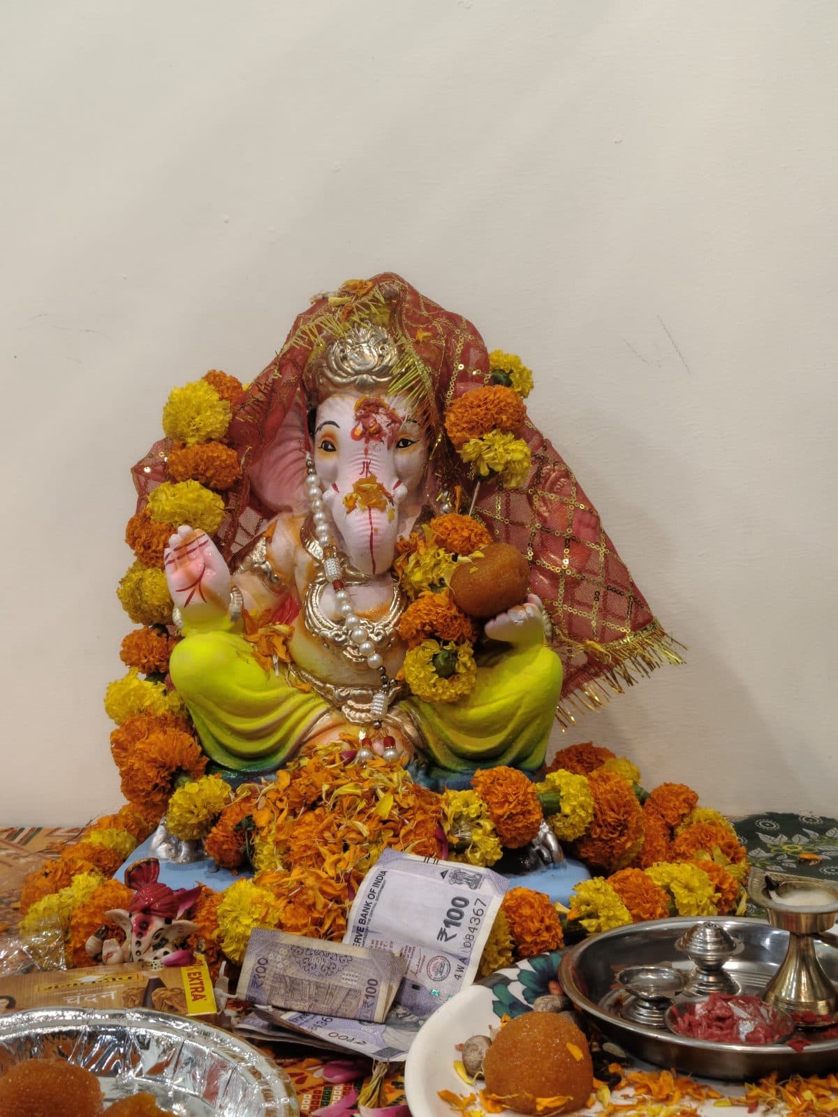 Ganesh idol adorned with marigold garlands and offerings at the TradeAura Institute Ganesh Chaturthi puja