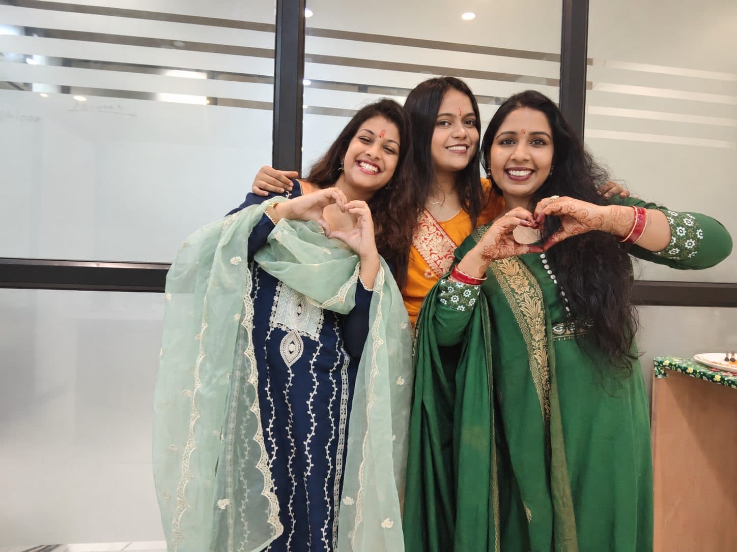 Three TradeAura team members making heart gestures on Ganesh Chaturthi