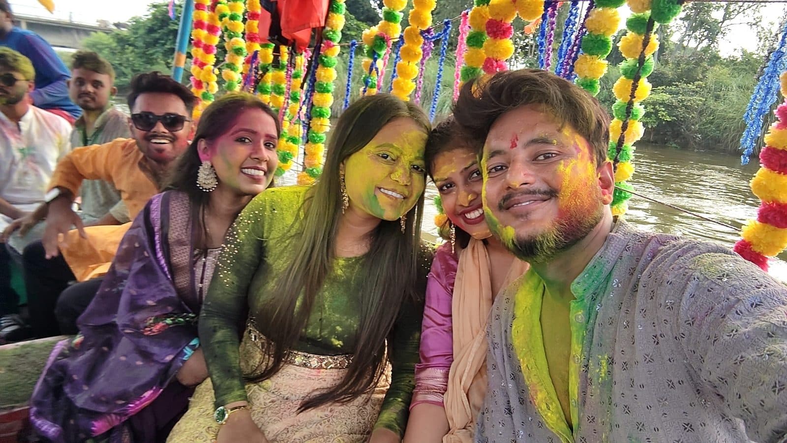 TradeAura team covered in gulal on a decorated boat during Ganesh visarjan