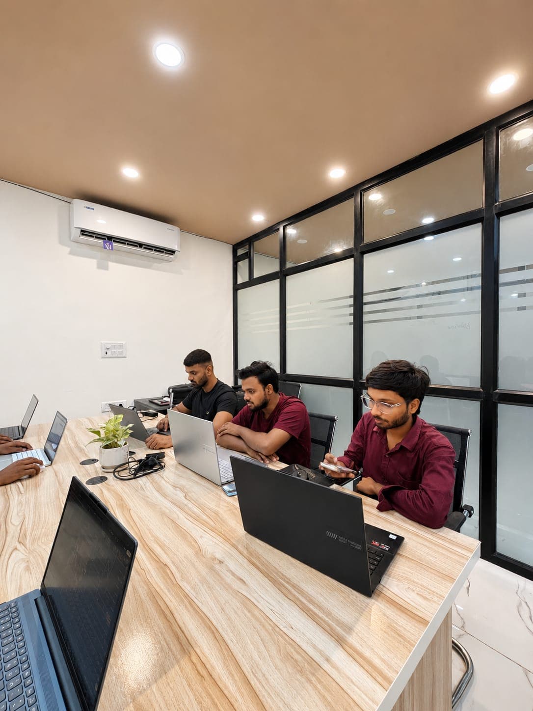 Modern, air-conditioned trading classroom with glass partitions and workstations at TradeAura Institute