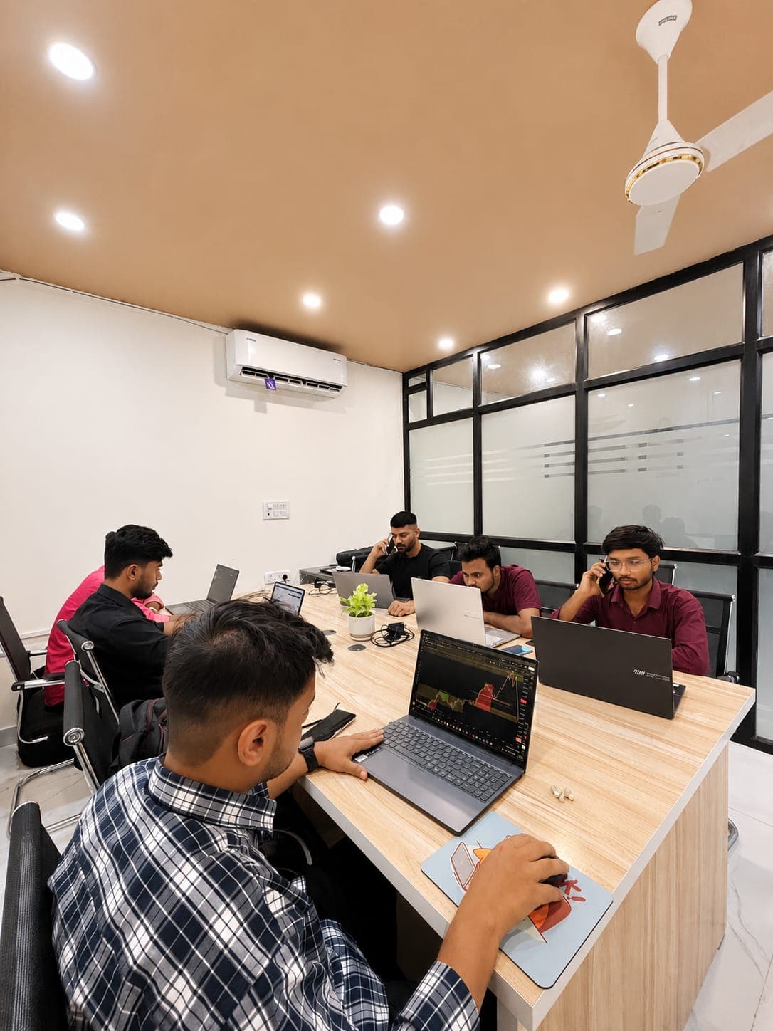 Group of students practising chart analysis together on laptops at TradeAura Institute